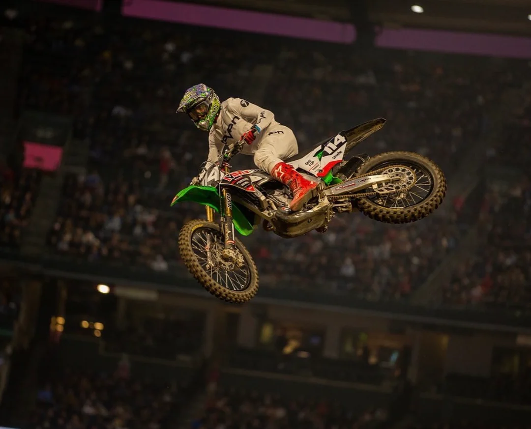 Geran Stapleton competing in Supercross on a green motorcycle in a stadium